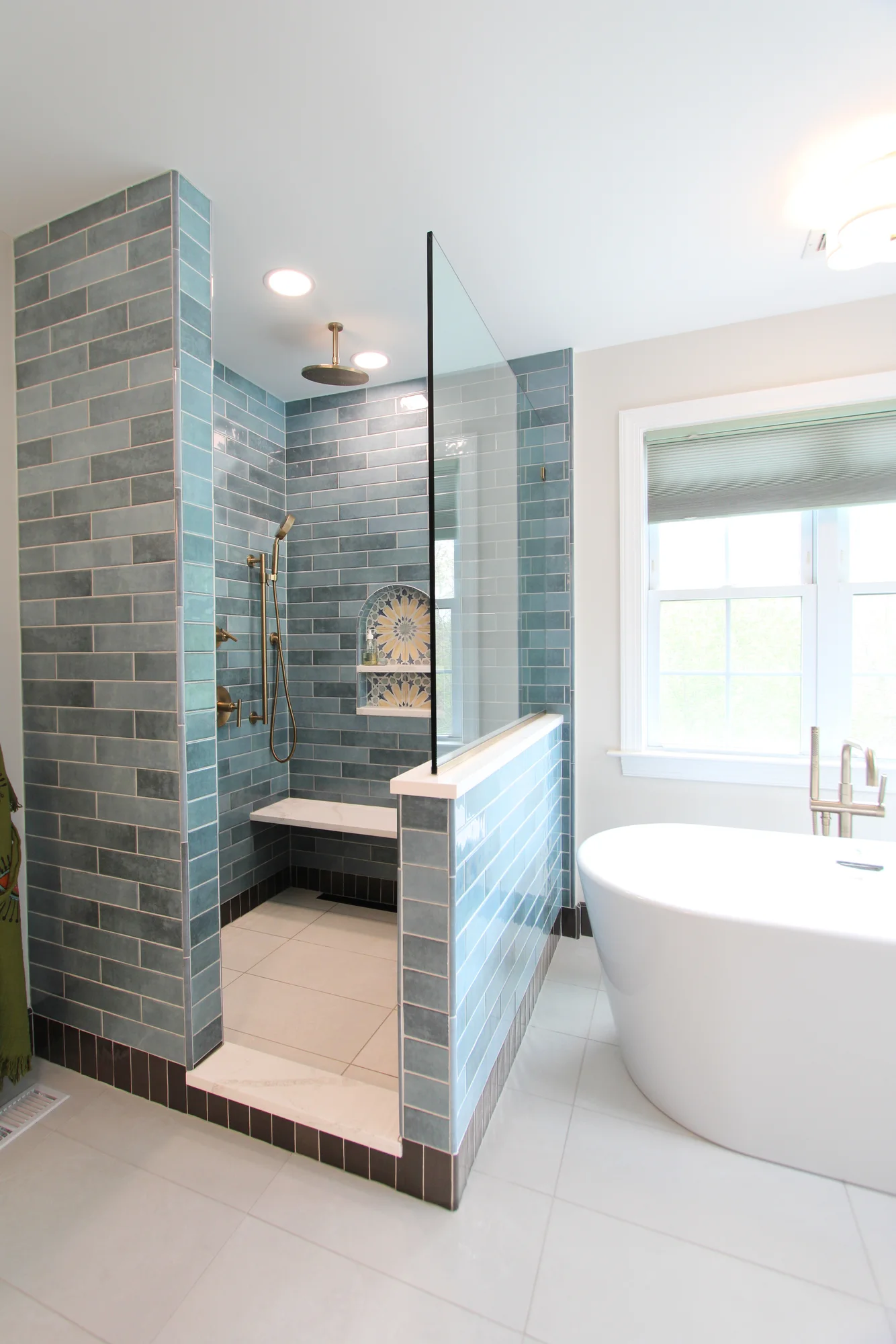 Luxury Doylestown primary bathroom with walk-in shower, soaking tub, green tile and brass fixtures