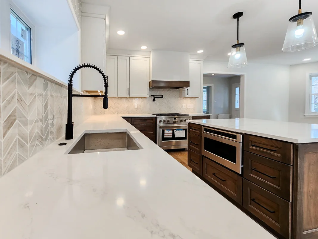 Chevron tile backsplash with quartz countertop and wood cabinetry in a Bala Cynwyd kitchen remodel