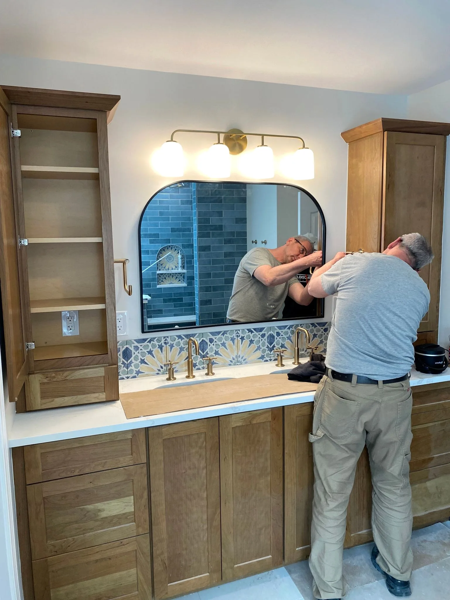 dRemodeling craftsman completing a bathroom installation.